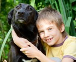 Boy with black Labrador Retriever